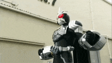 a man in a black and silver costume is standing in front of a building with a 7r sign on it