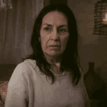 a woman with long dark hair looks at the camera