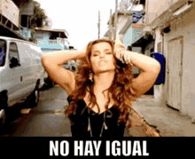 a woman is standing on a street with a sign that says no hay igual on it