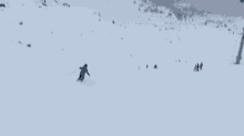 a man is skiing down a snow covered slope .