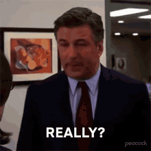 a man in a suit and tie is making a funny face and says `` really '' .
