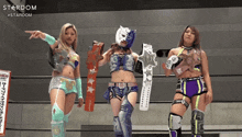 three female wrestlers standing next to each other with stardom written on the bottom right