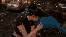 a woman in a black top is holding a man 's arm in a video game