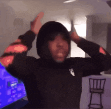 a person wearing a black hoodie with a white arrow on the front