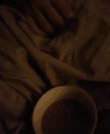 a cup of coffee is on a table next to a blanket