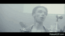 a man singing into a microphone with makeagif.com at the bottom