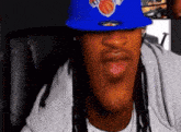 a man wearing a blue hat with the new york knicks on it