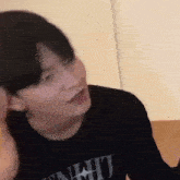 a man wearing a black shirt is making a funny face .
