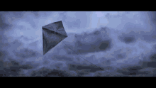 a kite is flying in a cloudy sky with a gray background