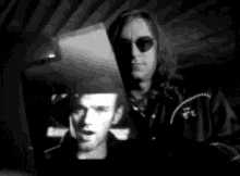a man in a cowboy hat is looking at a picture of another man .