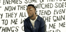 a man stands in front of a wall that says enemies some of them now they witched sides