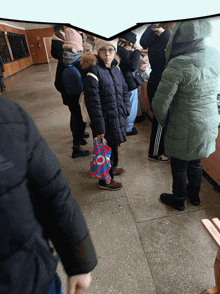 a group of people are standing in a hallway and one of them is holding a bag that says " ok "