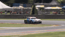 a race car is going around a curve on a track with a sign in the background that says ' toyota ' on it