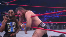 two men in a wrestling ring one of whom is wearing a shirt that says fesse lub
