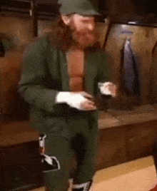 a man with a beard is wearing boxing gloves and a hat .
