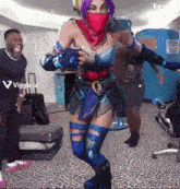a woman with purple hair and a red scarf on her face is dancing in a room with a sign that says viggle.ai