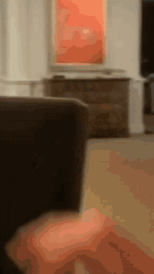 a blurry picture of a living room with a couch and dresser in the background