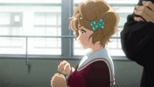 a girl with a blue bow in her hair looks at something