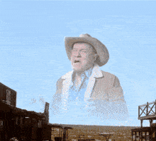 a man in a cowboy hat stands in front of a sign that says " hhh "