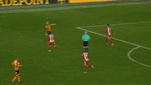 a soccer goalie is diving to catch a ball in front of a wall that says sportpesa