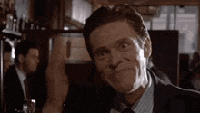 a close up of a man in a suit and tie making a funny face .