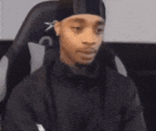 a person wearing a black hat is sitting in a chair