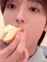 a close up of a person eating a piece of bread with a bite taken out of it .