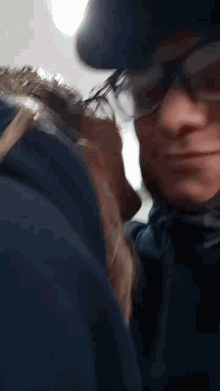 a blurry picture of a man wearing glasses and a black hat