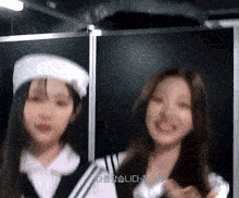 two girls are standing next to each other and one of them is wearing a beret