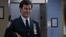 a man in a police uniform has a patch on his shoulder that says ' nypd ' on it