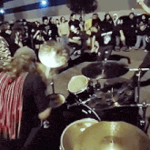 a drummer is playing in front of a crowd of people