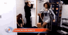 a woman in a silver dress is dancing in a room with a man in a suit .