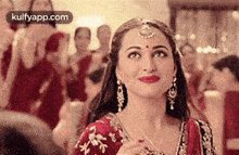 a woman in a red dress is smiling in front of a crowd .