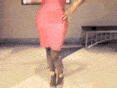 a woman in a red dress is standing on a tiled floor .