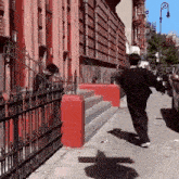 a man is running down a street in front of a building