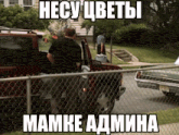 a man in a black shirt is standing next to a red truck with a cooler in the back of it