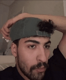 a man with a beard is wearing a baseball cap on his head