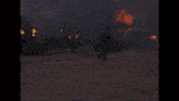 a man is standing in front of a burning house holding a gun