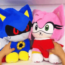 a person is petting a stuffed sonic and amy rose