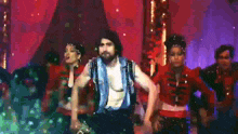 a man without a shirt is dancing in front of a group of women .