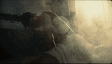 a woman is laying down in the rain with a white towel around her waist
