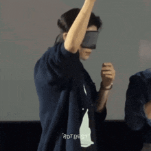 a man wearing a blindfold and a shirt that says adt best on it