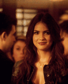 a woman with a necklace around her neck is smiling