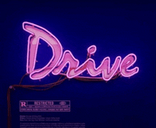 a neon sign that says drive with a warning label below it