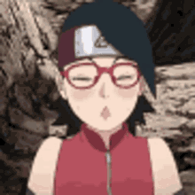 a close up of a girl wearing glasses and a red shirt .