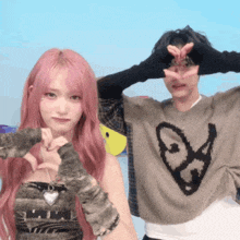 a man and a woman are making a heart shape with their fingers