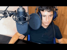 a young man wearing headphones and a microphone in front of a computer