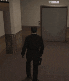 a man in a suit is walking in a hallway