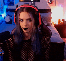 a woman wearing headphones and a black shirt looks at the camera