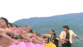 a group of people are dancing in front of a mountain range .